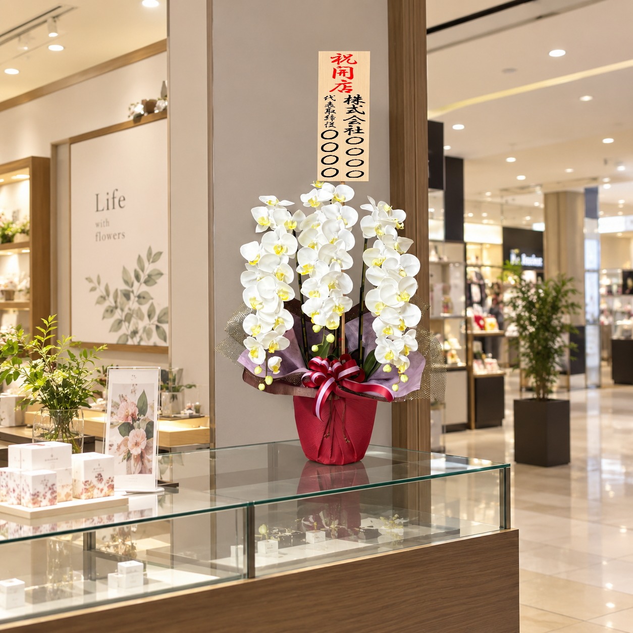 開店祝の立札を付けた光触媒造花胡蝶蘭type2・ラージ3本立ち(白)の設置イメージ画像(ショッピングセンター)