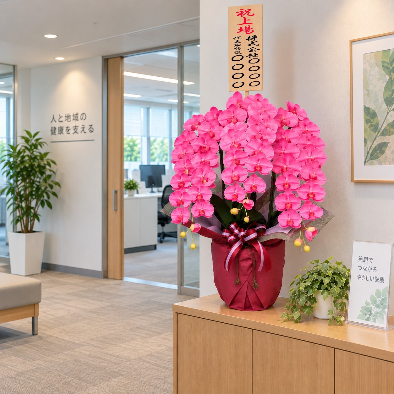 上場祝の立札を付けた光触媒造花胡蝶蘭・特大輪3本立ち・ピンク・ホワイト化粧鉢をオフィスに設置したイメージ画像)